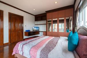 a bedroom with a large bed and a tv at Angel Pool Villa Phuket - SHA Exta Plus in Phuket Town