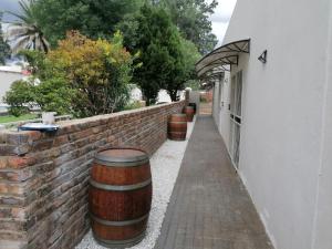 a brick wall with barrels next to a building at On Enslin selfcatering in Middelburg