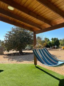 a blue hammock under a wooden pergola at Rotem's Trail in Netiv HaShayyara