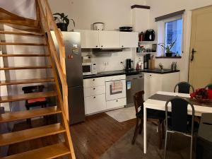 una cocina con mesa y una cocina con escalera en Petite maison choux, en Bouillon