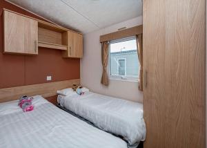 two beds in a small room with a window at Woodlands Hall in Ruthin