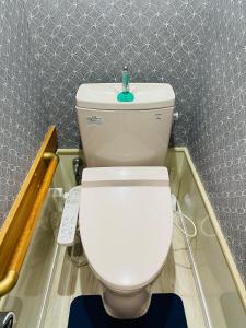a bathroom with a white toilet with a green faucet at Alo BnB 2 - Near NIPPORI, SENDAGI, YANAKA GINZA - Self check-in in Tokyo