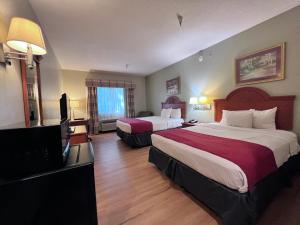 Habitación de hotel con 2 camas y TV de pantalla plana. en Americas Best Value Inn Wiggins, en Wiggins