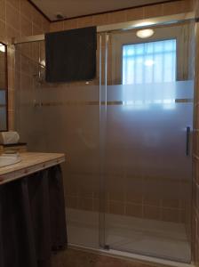 La salle de bains est pourvue d'une douche avec une porte en verre. dans l'établissement Le nid de mésanges, à Chauffour-sur-Vell