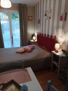 1 dormitorio con cama, ventana y mesa en Le nid de mésanges en Chauffour-sur-Vell