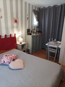 a bedroom with a bed with a pillow and a table at Le nid de mésanges in Chauffour-sur-Vell