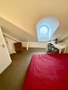 a bedroom with a red bed and a desk and a window at TOURS quartier halles 70m2 in Tours