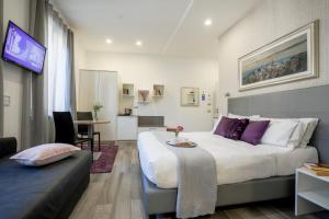ein Schlafzimmer mit einem großen Bett mit lila Kissen in der Unterkunft Monza City Rooms & Studios in Monza