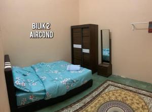 a bedroom with a bed and a dresser and a mirror at Spar Homestay 2 in Kota Bharu