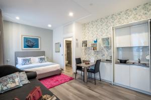 a bedroom with a bed and a table and a kitchen at Monza City Rooms & Studios in Monza