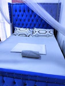 un lit bleu avec une tête de lit bleue et un oreiller bleu dans l'établissement Bamburi Luxury Homes 2, à Bamburi