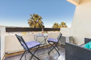 um pátio com uma mesa e cadeiras numa varanda em Sunset 755 Naturist Port Nature em Cap d'Agde