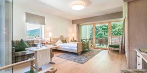 un soggiorno con divano, letto e finestre di Hotel Zur Schanz a Ebbs
