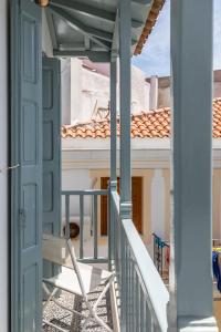 uma porta que leva a uma varanda com uma cadeira em Marialena Rooms em Skopelos