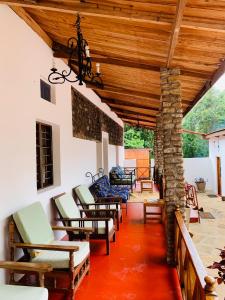 Marangu的住宿－Mrefu Eco-lodge，一个带椅子的门廊和木制天花板