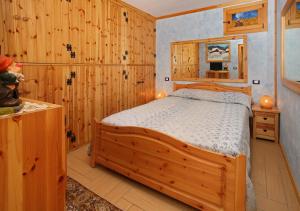 a bedroom with wooden walls and a bed in a room at Salone House in Sauze dʼOulx