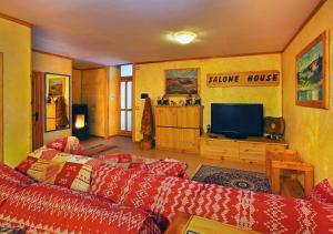 een woonkamer met een bank en een televisie bij Salone House in Sauze dʼOulx