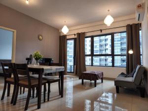 a living room with a dining room table and chairs at Cozy 2BR APT @Ampang Embassy Row in Kuala Lumpur
