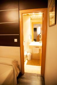 a bedroom with a bathroom with a sink and a toilet at Hotel Universal in Granada