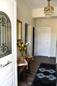 un couloir avec une table et un vase de fleurs dans l'établissement Sitos Home, à Sparte