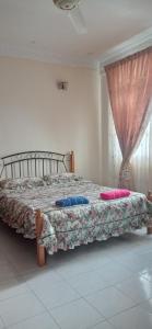 um quarto com uma cama com almofadas em Homestay Rumah Singgah em Jitra