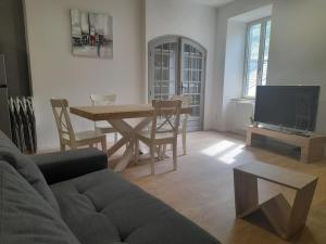 a living room with a couch and a table and a tv at Appartement Duplex 8 personnes proche télécabines in Ax-les-Thermes