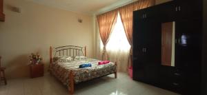 um quarto com uma cama e uma janela em Homestay Rumah Singgah em Jitra