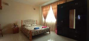 a bedroom with a bed and a window at Homestay Rumah Singgah in Jitra
