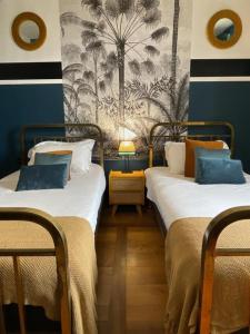 two beds in a room with blue and white walls at Le Boutik Hotel in Annecy