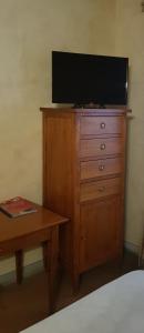 uma televisão em cima de uma cómoda com uma mesa em B&B Palazzo Al Torrione 2 em San Gimignano