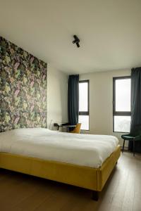 - une chambre avec un grand lit et du papier peint floral dans l'établissement UNIEK appartement - mooiste en hoogste uitzicht op Antwerpen! - incl gratis parking, à Anvers