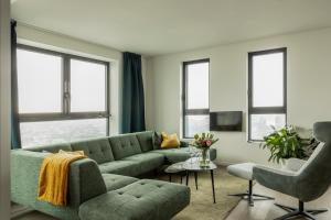 sala de estar con sofá verde y sillas en UNIEK appartement - mooiste en hoogste uitzicht op Antwerpen! - incl gratis parking, en Amberes