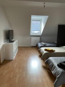 a room with three beds and a television in it at - SANO Apartments - DGR - Hagen Zentral - Free Parking - WIFI - Washing Machine in Hagen