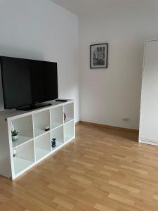 a white entertainment center with a flat screen tv on it at - SANO Apartments - DGR - Hagen Zentral - Free Parking - WIFI - Washing Machine in Hagen