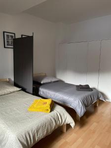 a bedroom with two beds and a yellow shirt on the bed at - SANO Apartments - DGR - Hagen Zentral - Free Parking - WIFI - Washing Machine in Hagen