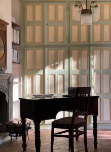 een piano in een kamer met een muur van ramen bij La Corte Delle 4 Stagioni in Ozzano Monferrato