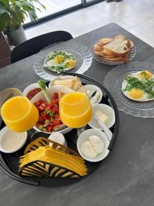 bandeja de desayuno en una mesa con vasos de zumo de naranja en יחידה מושלמת ברמת ישי לזוג או יחיד, en Ramat Yishay