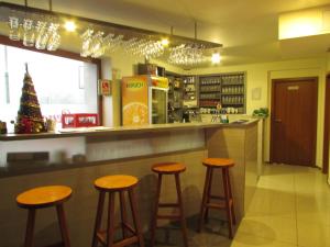 a bar with stools in a kitchen with a christmas tree at Penzión Trio in Trnkov