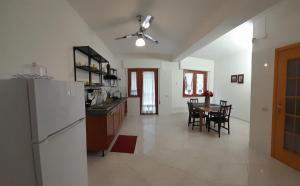 a kitchen and dining room with a refrigerator and a table at Oasi home in Casteldaccia