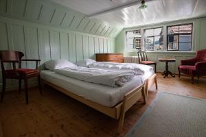 a bedroom with a bed and two chairs and a window at Gasthaus Rössli in Trogen