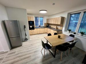 a kitchen with a table and chairs and a refrigerator at Bungalov Božena in Česká Lípa