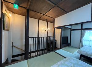 een kamer met een balkon, een bed en een televisie bij 浪漫宿花町 in Mitarai