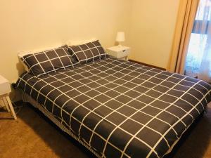 a bedroom with a black and white bed with two night stands at Golden House in Springvale
