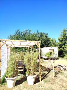 a garden with potted plants and a wooden pergola at Les gorges du Verdon in Riez