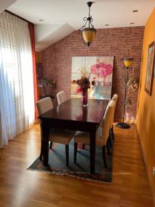 a dining room with a table and chairs and a brick wall at Atractivo Ático 2 Habitaciones in Villaviciosa +7 photos