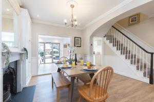 uma sala de jantar com uma mesa e uma lareira em Beautiful Period Home with Five Bedrooms em Cheltenham