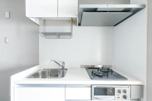 a white kitchen with a sink and a stove at Oyado Shinmachi Gojo in Kyoto +48 photos