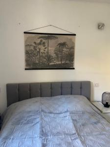 Una cama en un dormitorio con un cuadro en la pared. en La Ciotat vue mer emplacement exceptionnel avec parking, en La Ciotat