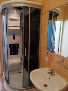 uma casa de banho com um chuveiro e um lavatório. em Gamma Hotel em Līvāni