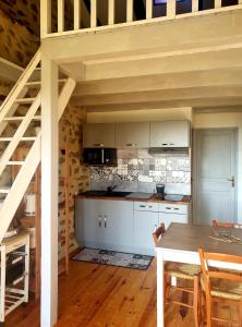 uma cozinha com armários brancos e uma mesa de madeira em La Chabanade em Saint-Pierre-Eynac